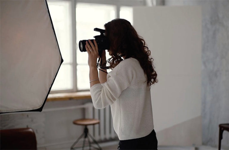 Young woman filming explainer video instructions in a studio with professional lighting