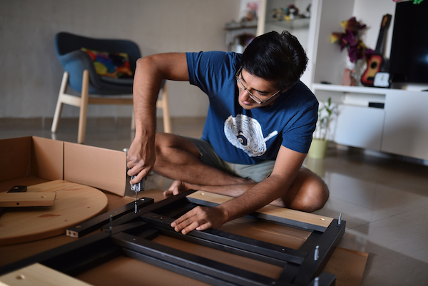 Man in India assembling flat-pack furniture using the BILT app