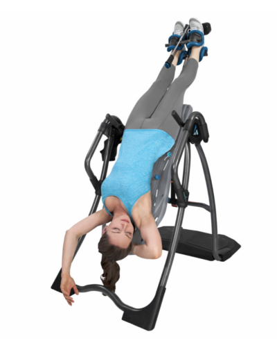 woman hanging upside down on a Teeter Inversion Table