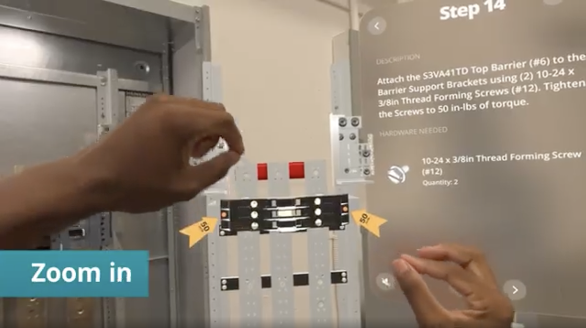 Training employee's right and left hands are shown six inches apart in the air and creating a pinching gesture to manipulate a virtual screen in the Apple Vision Pro headset